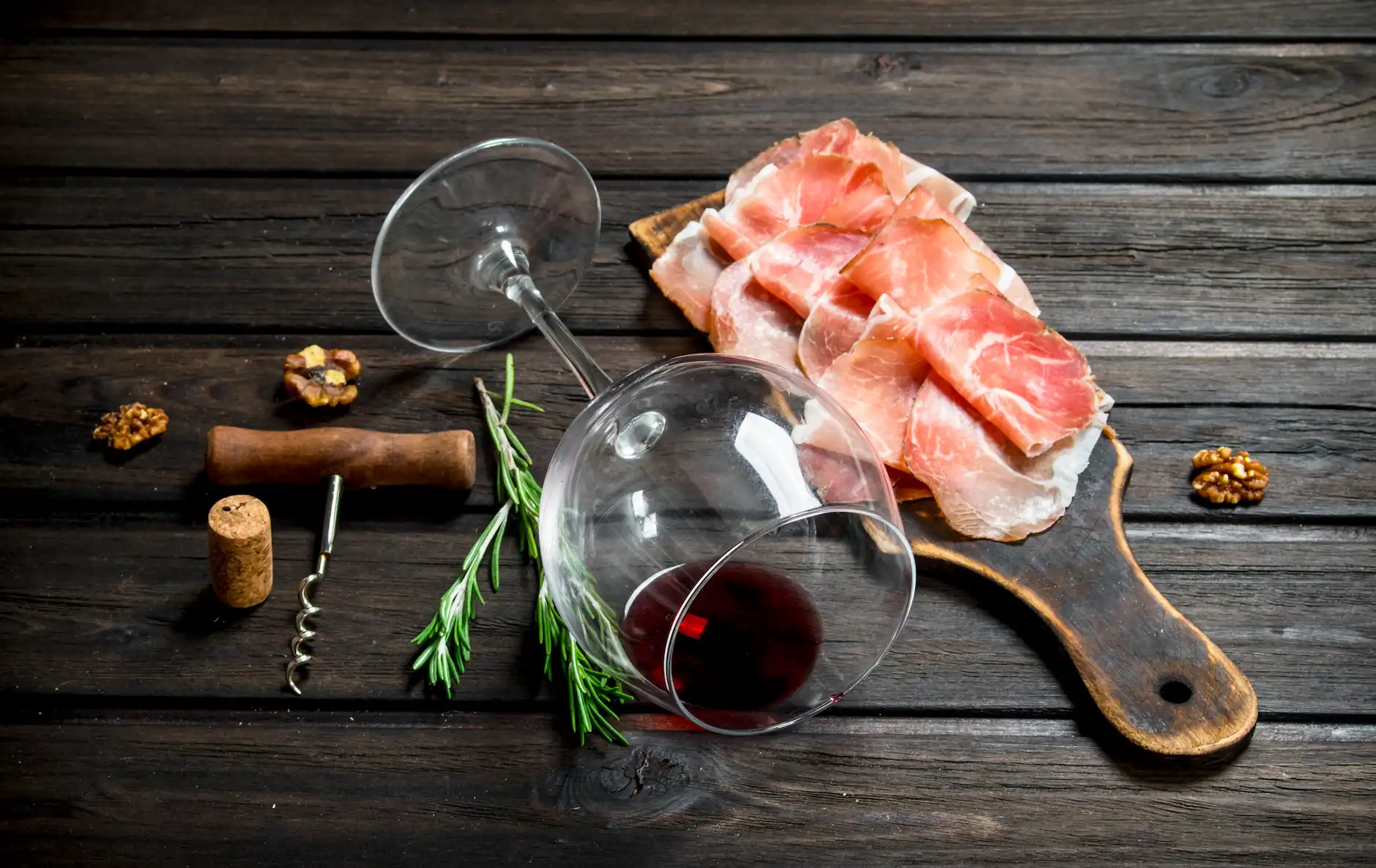 Copa de vino y tabla de corte con jamón